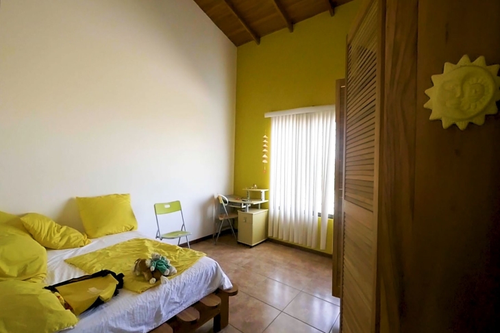 yellow bedroom in Finca Las Nubes home and land for sale samara guanacaste costa rica