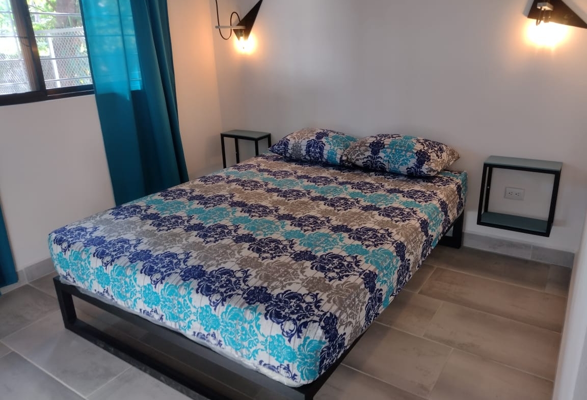 queen sized bed with blue bed spread in Casa espinoza home for sale samara costa rica