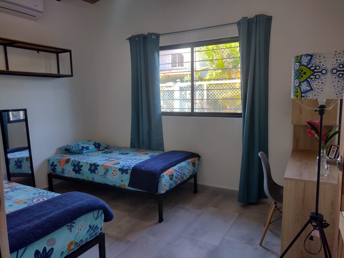 bedroom with two beds and desk in Casa espinoza home for sale samara costa rica