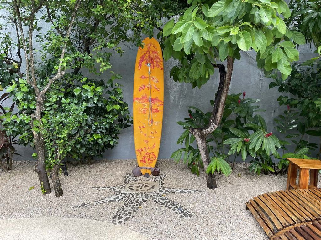 Original outdoor shower with surfboard of Relax Lodge hotel and rental income property, for sale atSamara Beach, Guanacaste, Costa Rica