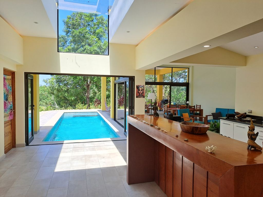large glass doors open on the pool at Casa Ananda home for sale Carillo Beach samara costa rica
