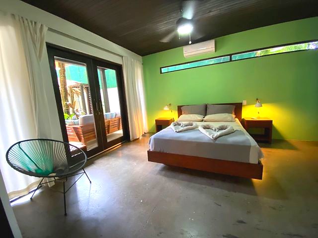 Green bedroom at The Urban Sanctuary Lodge hotel and rental income property, for sale at Samara Beach, Guanacaste, Costa Rica