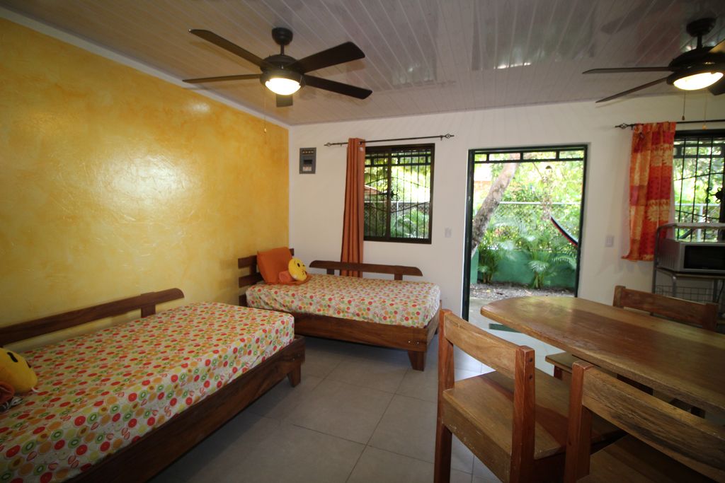 two single beds with table and chairs in Casa Nela, hotel and rental income property for sale at Samara Beach, Guanacaste, Costa Rica