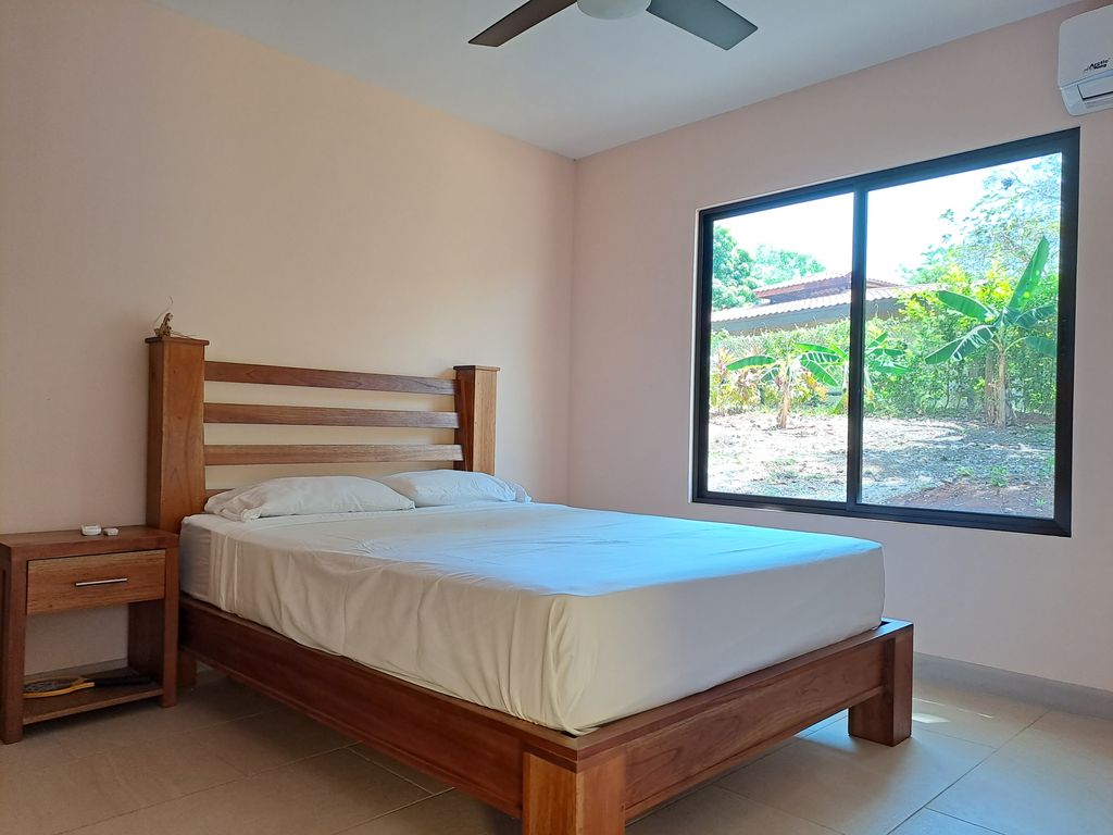 queen sized bed in bedroom of Casa Ananda home for sale Carillo Beach samara costa rica