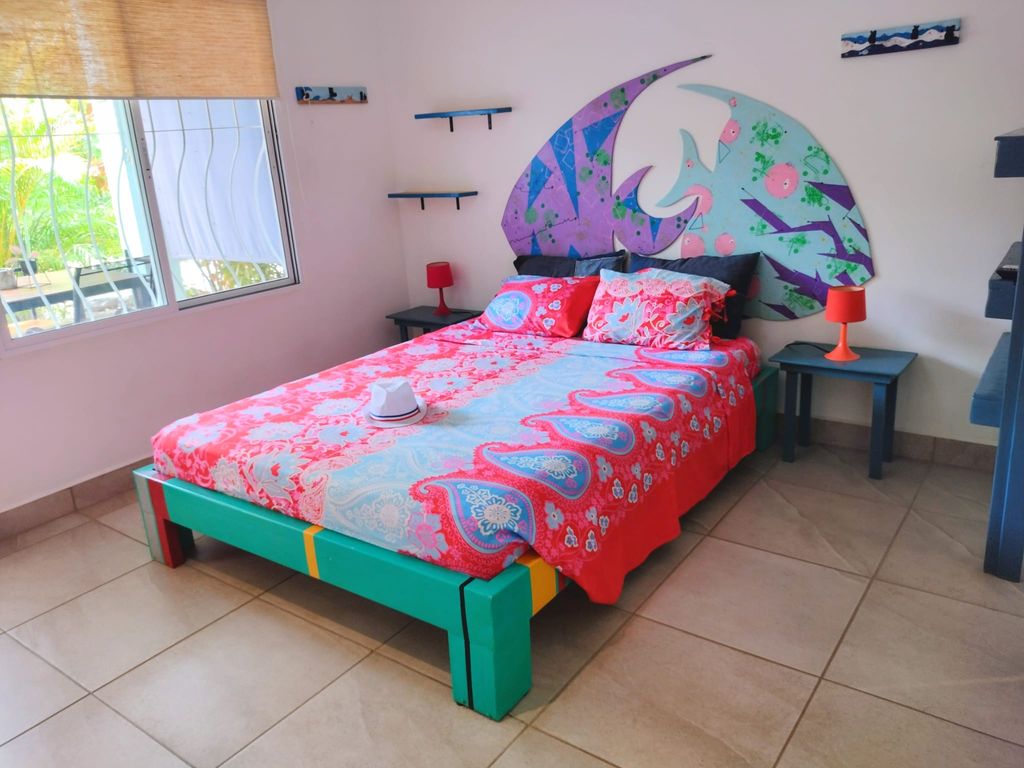 colored queen sized bed in bedroom of Casa ceiba hotel and rental income property for sale at Samara Beach Guanacaste Costa Rica
