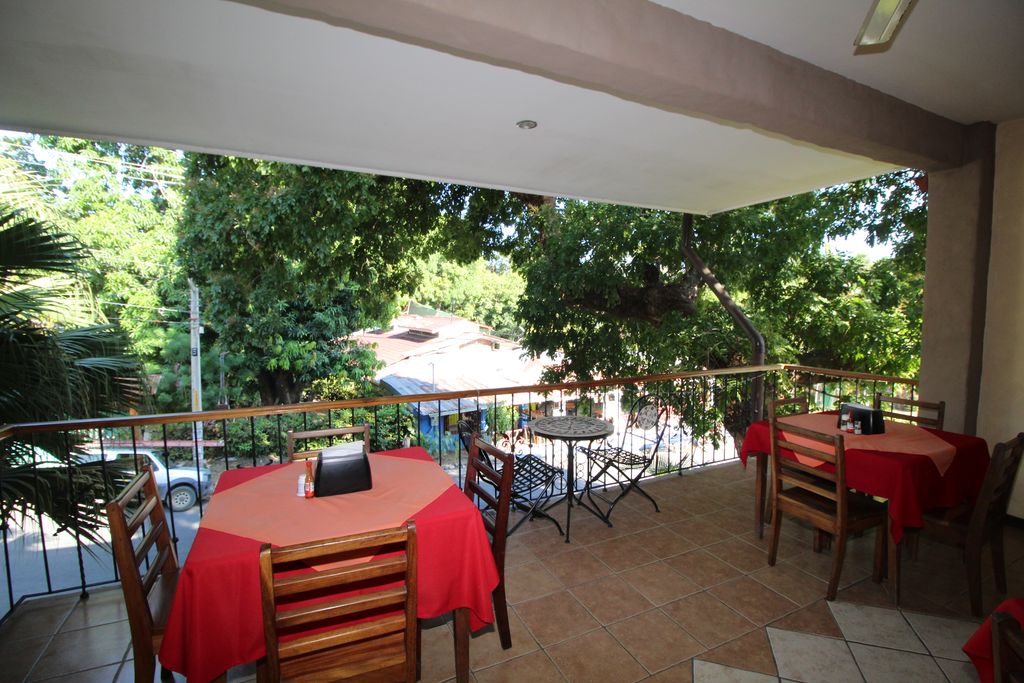 Outdoor terrace with tables of Casa Emerald, Restaurant and Cabinas for sale at Samara Beach, Guanacaste, Costa rica