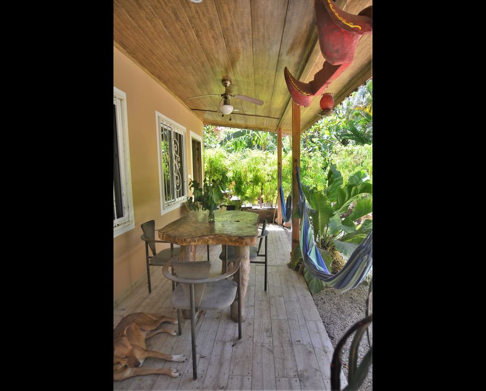 Covered terrace and dog at Casa La Isla, rental income property for sale at Samara Beach, Costa Rica