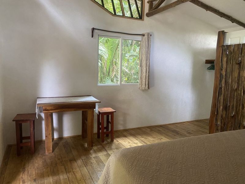 bedroom with wooden floor table and chairs at the holistic yoga retreat hotel for sale samara guanacaste costa rica