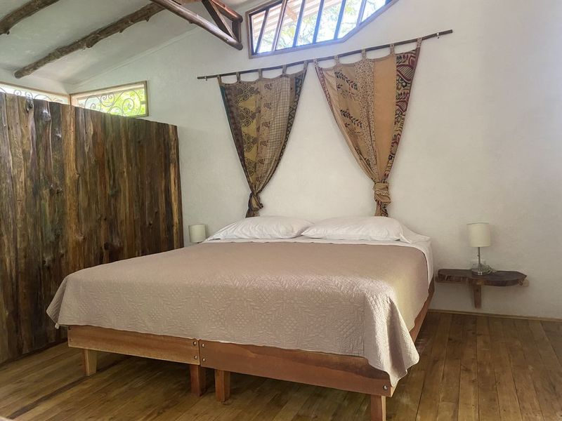 double bed with curtains above in the holistic yoga retreat hotel for sale samara guanacaste costa rica