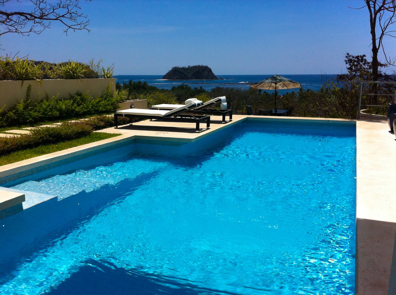 Blue simming pool with long chairs Samara Reef Condos luxury real estate for sale samara Guanacaste Costa Rica
