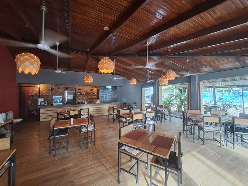 large dining area with eight tables and chairs at restaurant Porque Si business for sale Samara costa rica